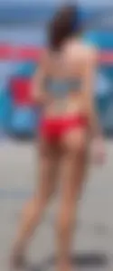 Skinny mature lady in red bikini bottom on the beach playing volleyball