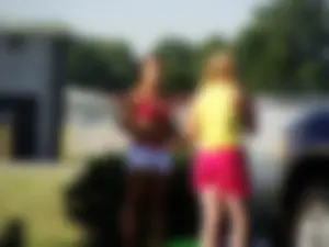 Group of cute girls at a car wash in bikinis and shorts