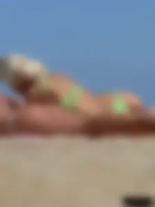 Hot blonde on the beach topless and in a white thong bikini