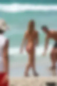 Topless girl in a tiny thong on the beach playing paddle ball