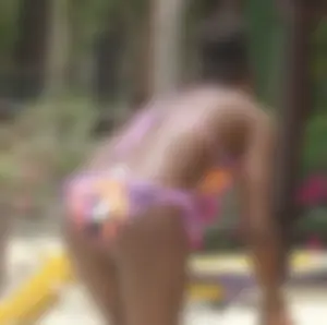 Sexy black babe in various bikinis on the beach while on vacation