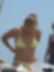 Sexy blonde on the beach in a yellow thong bikini