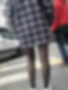 Cute candid girl with legs in black pantyhose waiting on the crosswalk