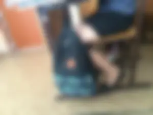 Girl in Flats, a Skirt and Pantyhose Sitting in Classroom