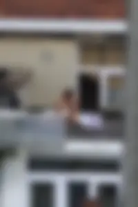 Neighbor on rooftop tanning in bikinis