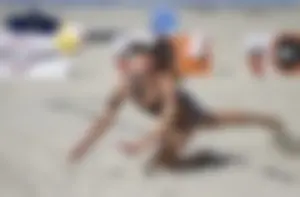 Hot girls playing beach volleyball in bikinis and shorts