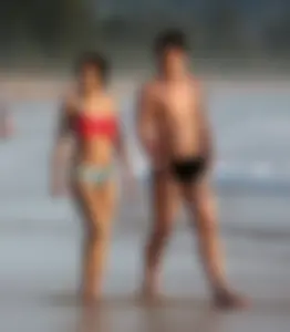Cute Asian in bikini on the beach with her boyfriend