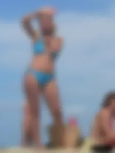 Sexy lady on the beach in a blue thong bikini