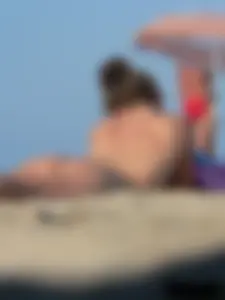 Sexy babe with a nice body topless and in a thong on the beach