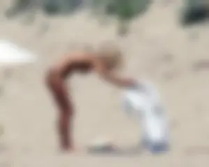 Small boobed topless milf on the beach