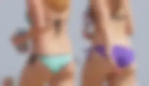 Cute girls in light blue and purple bikinis on the beach