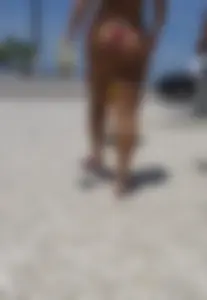 Big booty babe walking by the beach in thong