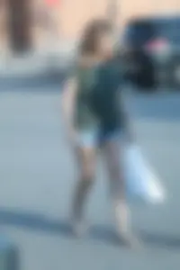Cutie walking in the parking lot in jean shorts