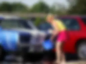 Group of cute girls at a car wash in bikinis and shorts