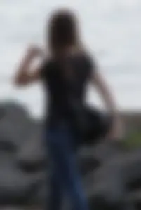 Cute brunette in jeans by the water