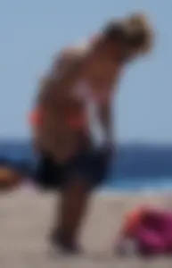 Thick blonde girl in an orange bikini on the beach