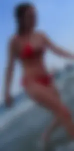 Sexy girl at the beach in a red thong bikini with nice tits and ass