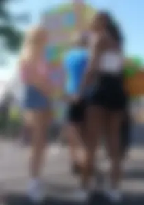 Group of candid teens in shorts at the amusement park