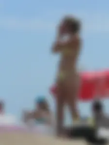 Sexy blonde on the beach in a yellow thong bikini