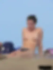 Sexy babe with a nice body topless and in a thong on the beach
