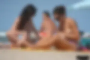 2 topless girls at the beach in thongs