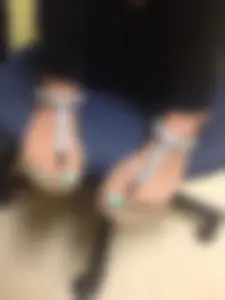 Closeup Photo of Feet With Pedicure in Slippers - Girl Sitting in an Office Chair With Bent Legs