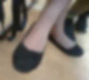 Teen Girl’s Feet in Pantyhose and Flats Under Desk Closeup Photo