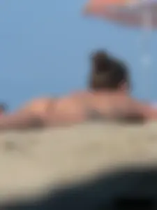 Sexy babe with a nice body topless and in a thong on the beach