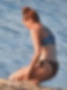 Sexy beach girl in a Nike sports bra and black bikini bottom
