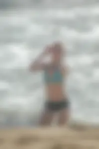 Blonde lady on the beach in bikini top and spandex shorts with a nice gap