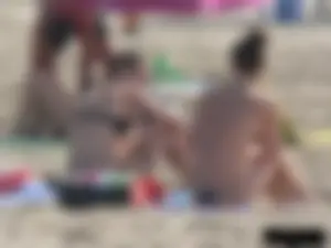 Sexy babe with a nice body topless and in a thong on the beach