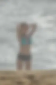 Blonde lady on the beach in bikini top and spandex shorts with a nice gap