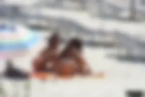 Topless milf and her topless daughter on the beach