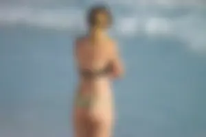 Sexy beach girl in thong bikini almost has a pussy slip