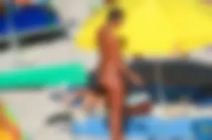 Nudist couple on the beach, girl has amazing tits and nice ass in a thong