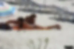 Topless milf and her topless daughter on the beach