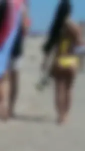 Beach babe with a nice ass and big tits in yellow thong bikini