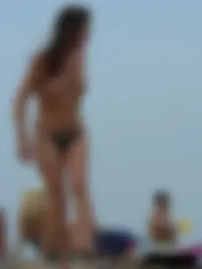 Sexy babe with a nice body topless and in a thong on the beach