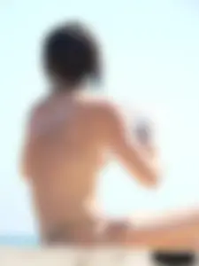 Topless beach milf looking sexy in a tiny g-string bikini