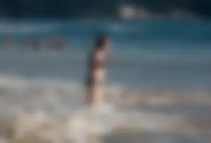 Cute bikini girl in the water in a black bikini