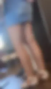 Legs closeups of a girl in jean skirt wearing sandals