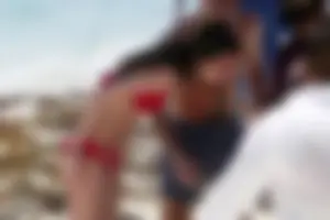Tall sexy skinny brunette on the beach in a red bikini