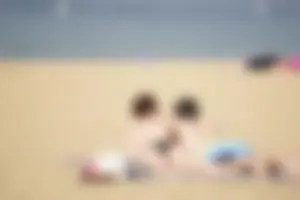 Sexy girl on the beach laying out and bending over in her bikini