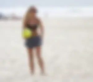 Hot girls playing beach volleyball in bikinis and shorts