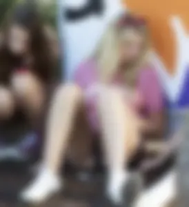 Hot blonde candid teen sitting on the ground in mini-shorts