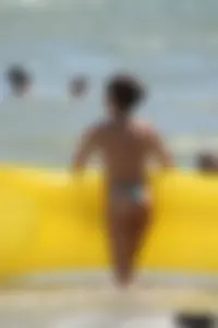 Blue thong lady in the water with a float