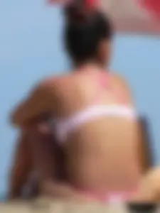 Hot brunette ethnic girl on the beach in a pink thong bikini