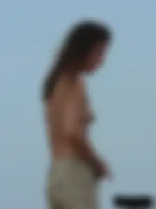Sexy babe with a nice body topless and in a thong on the beach