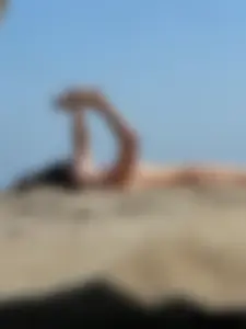 Topless beach milf looking sexy in a tiny g-string bikini