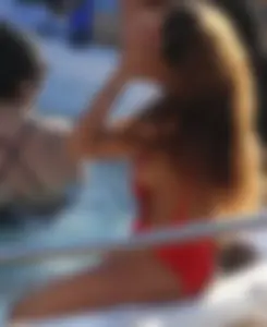Sexy black girl in red swimsuit at the pool with side boob and a nice ass